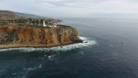 Epic sideways movement fly over video footage above lighthouse standing on a cliff 