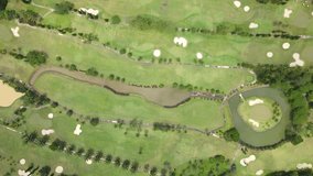 Drone fly over golf course in high altitude. Drone camera directly top down view of golf club.