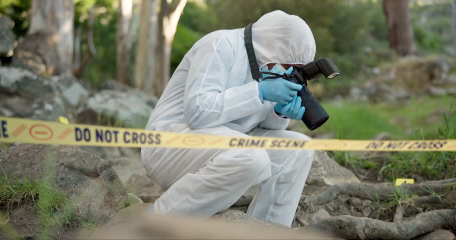 Forensic, photographer and police tape at crime scene for investigation in forest with evidence and safety hazmat..Csi quarantine, expert investigator and pictures for observation and case research