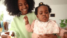mom with her african american daughter giving her healthy strawberry fruit snack - Powered by Shutterstock - Get 15% off with code: PIKWIZARD15
