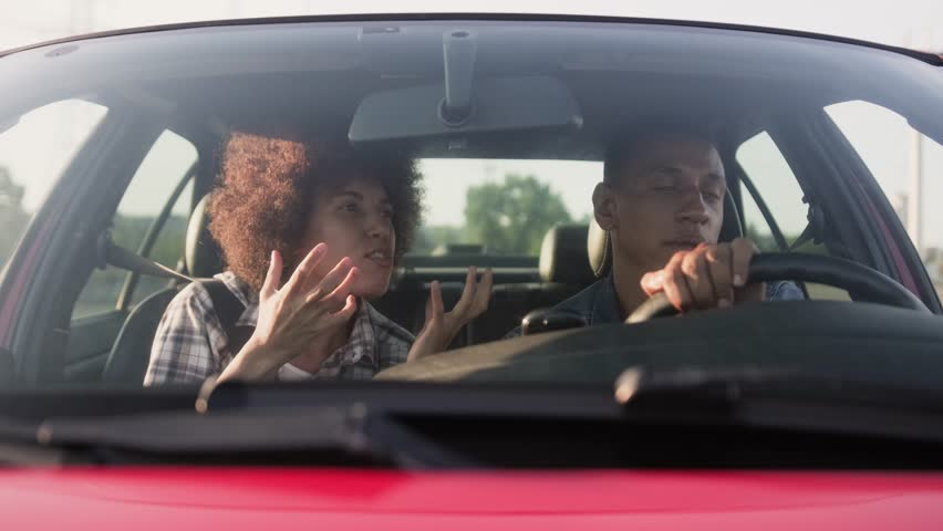 Young woman talking with man while driving in a car together. Slow motion Royalty-Free Stock Footage #3464728335