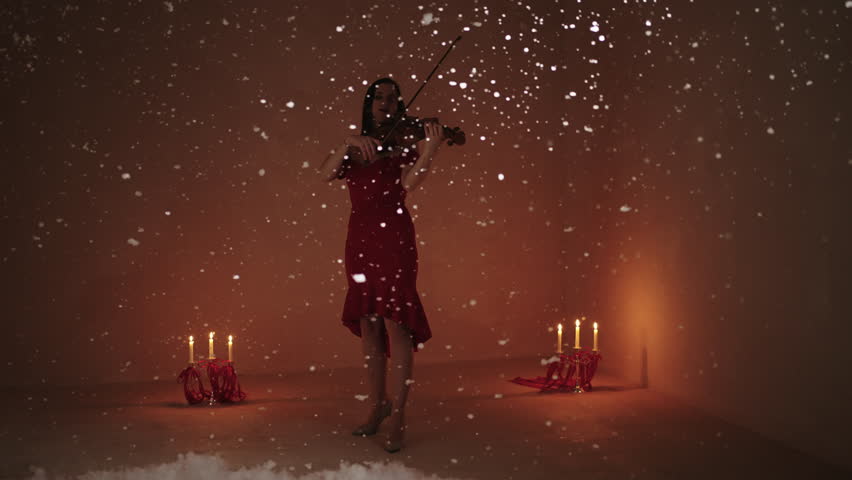 Emotional Woman Musician Playing Violin In Studio With Snow Flying Up, Full-Length Portrait