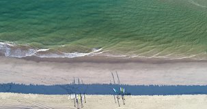 top view drone video of surfers getting ready to surf on the shore, aerial footage