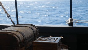 Antique pirate chest and carved Celtic viking box on a boat, sea glittering in the background. Maritime adventure, treasure chest, sailing ship details - Powered by Shutterstock - Get 15% off with code: PIKWIZARD15