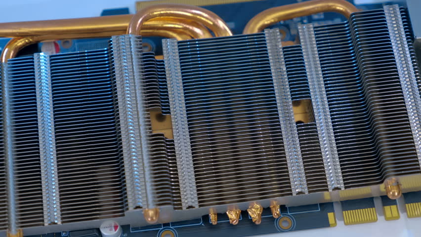 Powerful radiator with copper tubes for circulating coolant to cool the computer video card. Closeup. Macro. Shallow depth of field. Shot in motion