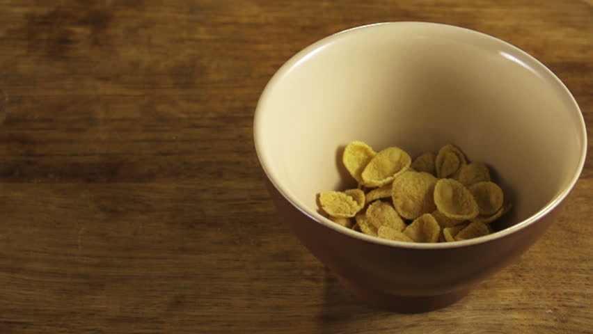 cereal flakes pouring in bowl on board