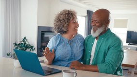 Excited mature couple with laptop at home using credit card to book vacation tickets or shop online - shot in real time - Powered by Shutterstock - Get 15% off with code: PIKWIZARD15