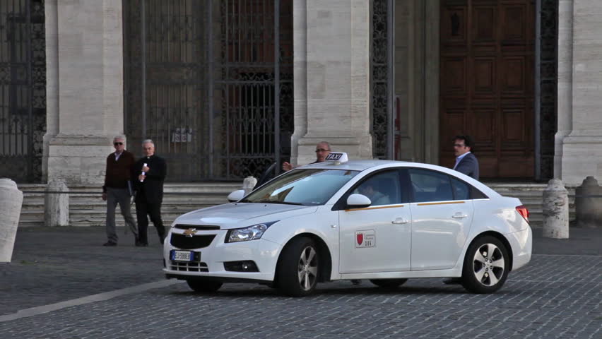 ROME - CIRCA MAY 2012: A group of men disembark a taxi in the Piazza San