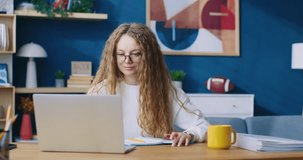Portrait of woman online work from home. Student surfing internet, browsing, using social media while relaxing in cozy apartment. Marketing financier, online education, remote job concept.