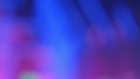 Abstract blurred background with colors in shades of blue and purple, with moving lights flashing like those of a music concert. Real time video.
