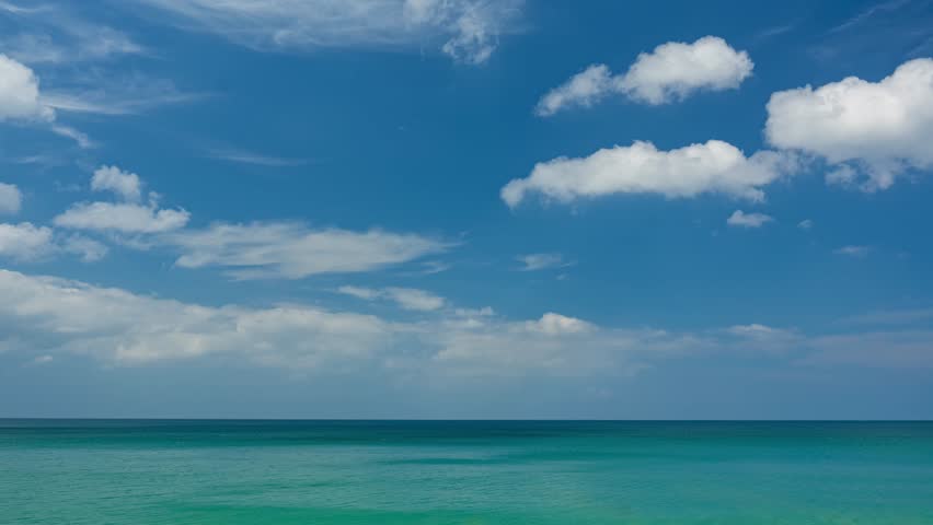 Timelapse nature landscape of Beach sea and clouds moving in the blue sky in good weather day.Sunlight reflected on the sea surface.Clouds traveling over the wide space of clear blue sky background