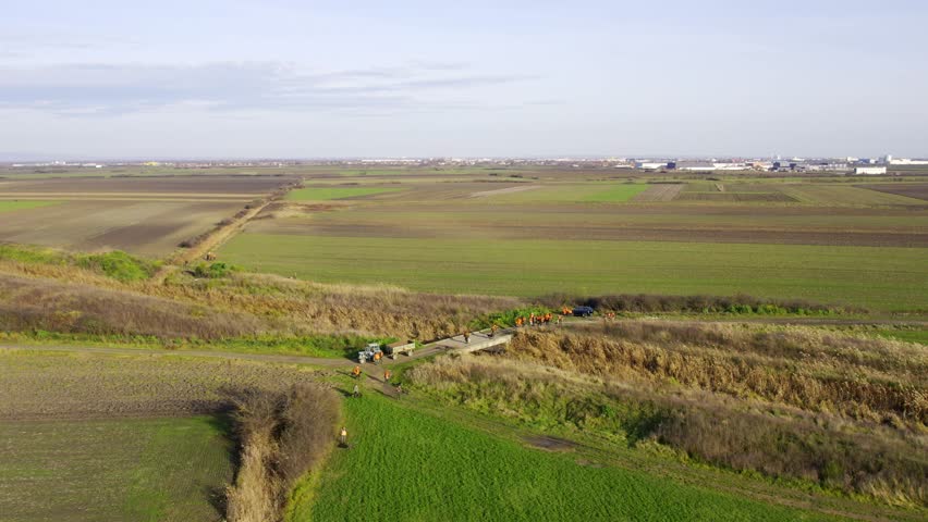 Aerial video of group of hunters on a bridge across shallow river in countryside