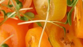 yellow cherry tomato slices and Micro-greens, rotation in circle. slice tomato with Little Sprouts, Turning. selective focus. useful background.  
vertical video