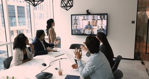In boardroom, diverse businesspeople engaged in virtual conference. CEOs, businessmen, and businesswomen collaborate, discuss strategy and deals via video call with international clients and investors
