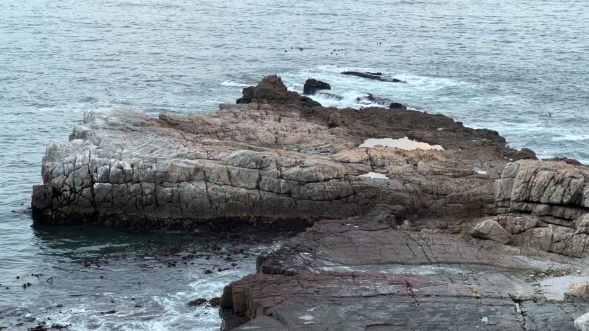 Massive boulders in the sea off the coast of Hermanus whale route at sunset Royalty-Free Stock Footage #3465186897