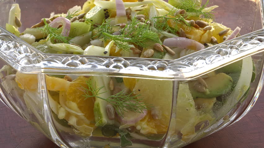 Citrus salad with fennel and avocado in a cristal glass bowl. Table spin.