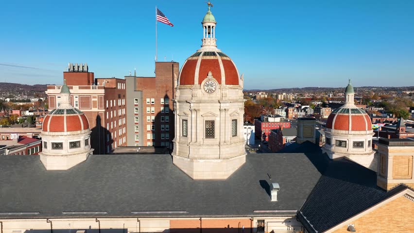 York County government building in autumn. Aerial rising shot revealing domes and American flag of city of York, Pennsylvania.