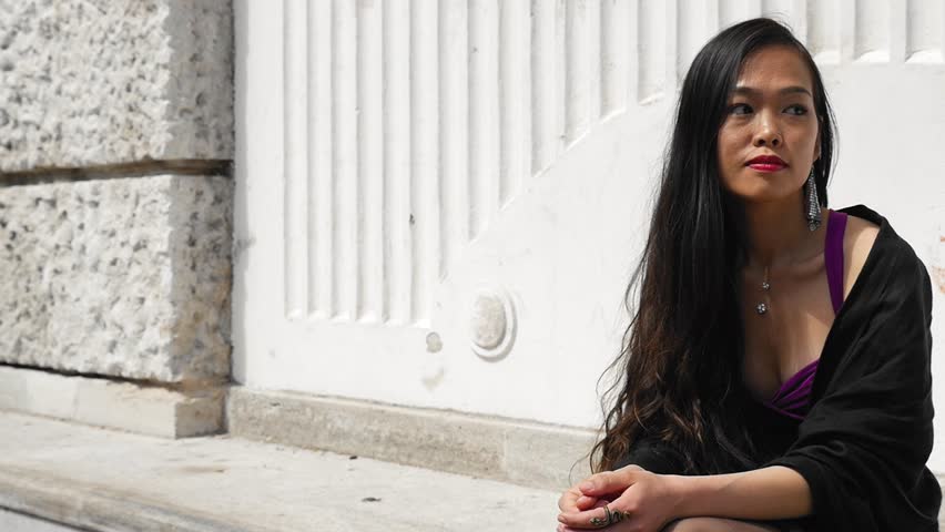 Elegant woman sitting by white pillars in Vienna