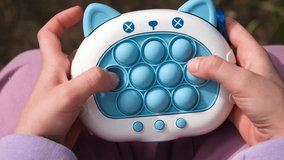 Close up video on electronic pop it fidget. Stress relieve toy pop it. Child playing Electronic Pop It. Simple board game