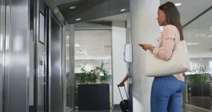 Video of diverse businessman and businesswoman waiting for elevator. business professionals and working in office concept.