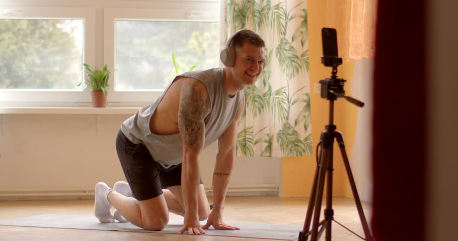 Fitness trainer during online workout session at home. Utilizing technology as smartphones and video conferencing platforms, participants engage in virtual fitness sessions from any location. Royalty-Free Stock Footage #3465428025