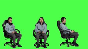 Young woman celebrating video games win against greenscreen backdrop, sitting on an office chair and playing online e sport tournament. Gamer feeling happy about winning worldwide game. Camera A.