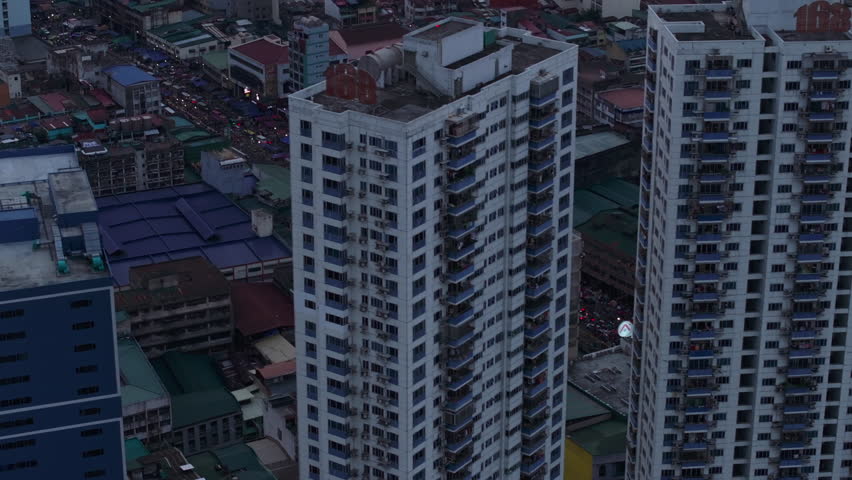 High angle view of buildings in city. Tilt up reveal sea coast. Dense town development in urban borough. Manila, Philippines