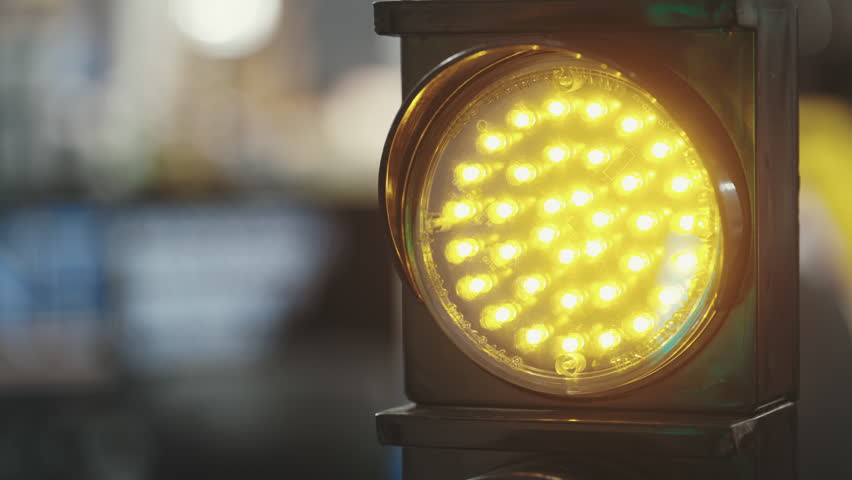 Yellow Flashing Beacon Alerts Drivers. Traffic light signal. Transportation Notification. Close-Up Perspective. Transport and Automobiles Concept