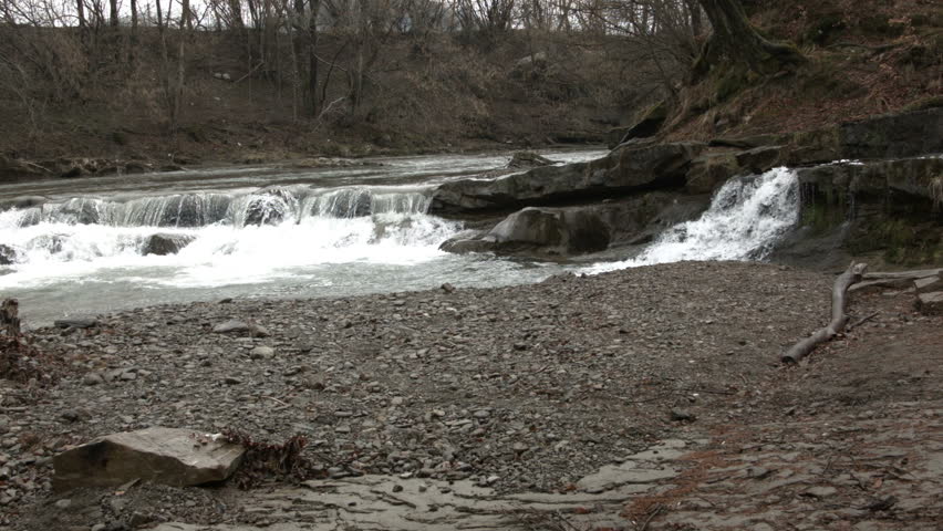 Young man dancing near a river in the mountains