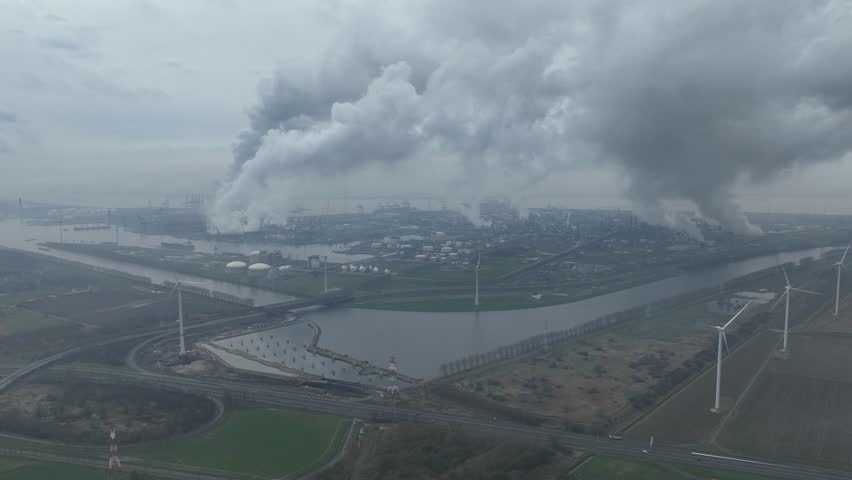 Aerial hyperlapse of chemical industry in operation in the port of Antwerp, Belgium. Transportation and production, smoke stacks clouds and smog. Industrial facility.