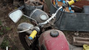 Old motorcycle in the dust. Red retro moto. Defective motorcycle, needs repair. A dirty rural gasoline motorcycle, next to it in the yard around the mess - Powered by Shutterstock - Get 15% off with code: PIKWIZARD15