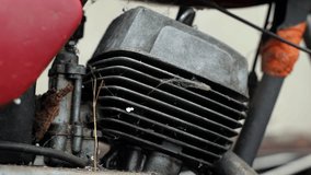 Old motorcycle in the dust. Red retro moto. Defective motorcycle, needs repair. A dirty rural gasoline motorcycle, next to it in the yard around the mess - Powered by Shutterstock - Get 15% off with code: PIKWIZARD15