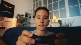 POV of excited young boy playing video game with joystick, losing competition