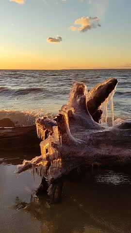 Winter on the seashore. Natural ice sculptures created by wind and wave. Sunset light background. Royalty-Free Stock Footage #3466064123