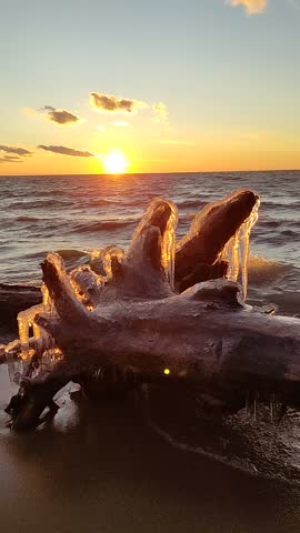 Winter on the seashore. Natural ice sculptures created by wind and wave. Sunset light background. Royalty-Free Stock Footage #3466064375