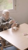 Senior people and caregiver playing cards in a nursing home