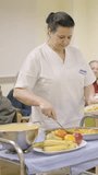 Cook serving food to seniors in a geriatric