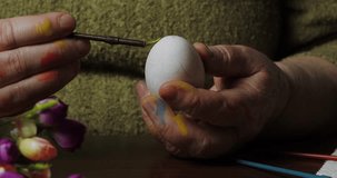 Close-up of a woman's hands painting Easter eggs
