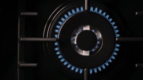 Gas burns blue, Heat and Mirage above the gas hob switched on. Top view of a kitchen burner glowing at night, close-up. Natural gas concept. The gas stove is on. Slow motion video