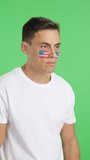 Happy man with USA flag painted on face looking away