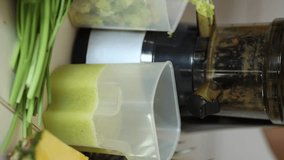Freshly squeezed juice came out from a juicer. Vertical video