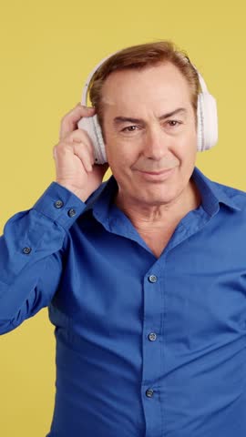 Smiley mature man listening to music with the mobile