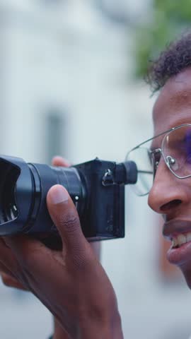 Close up view of a afro photographer taking a photo outdoors