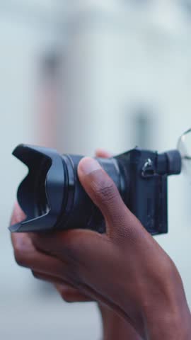 Close up view of a afro photographer taking a photo outdoors