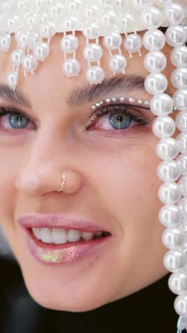 Woman smiling while wearing a wig of pearls