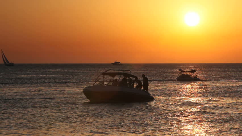 Ibiza Sunset at the sea with boats on the water
