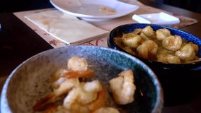 Video 1080p - sharing food in a chinese and japanese restaurant, taking shrimps and putting it in the plate
