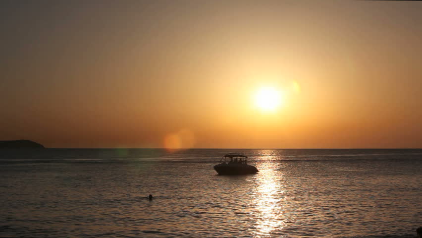 Ibiza Sunset at the sea with boats on the water
