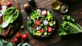 Salad bowl. Fresh vegetables salad cooked of lettuce leaves, cucumber, radish and tomatoes. Stock footage video 4k