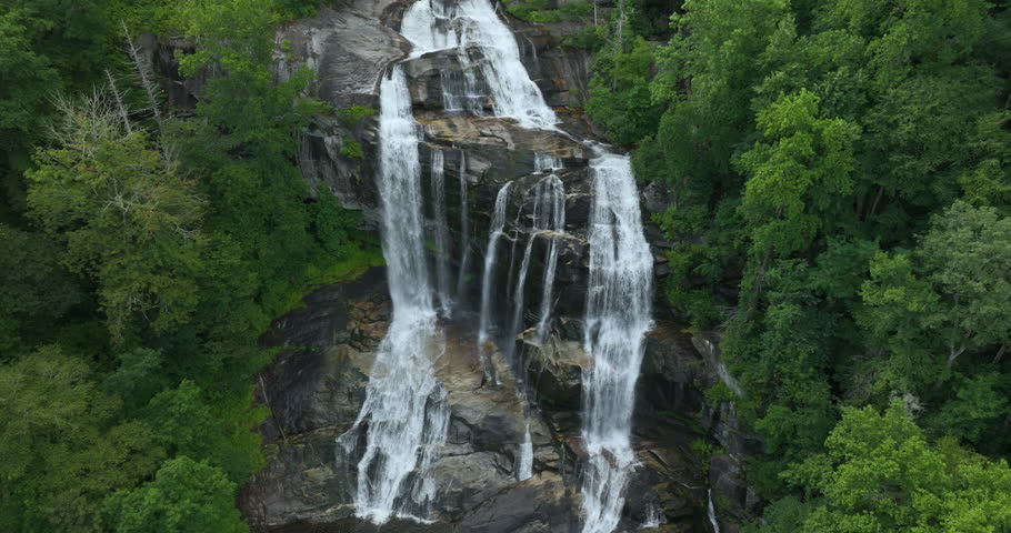 Whitewater Falls in Nantahala National Forest, North Carolina, USA. Clear water falling down from rocky boulders between green lush woods
